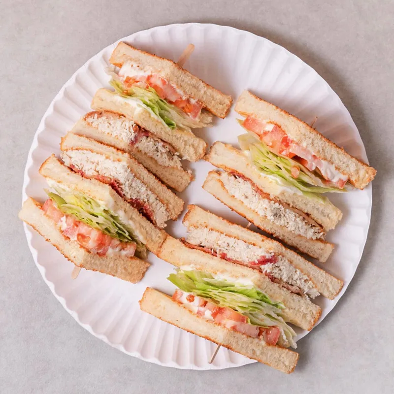 Club sandwich cut into quarters, served with fries