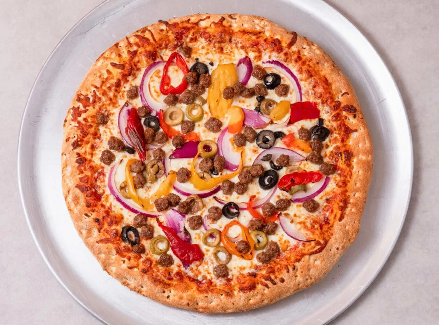 Pizza Deluxe avec bœuf haché, olives, poivrons et oignon rouge