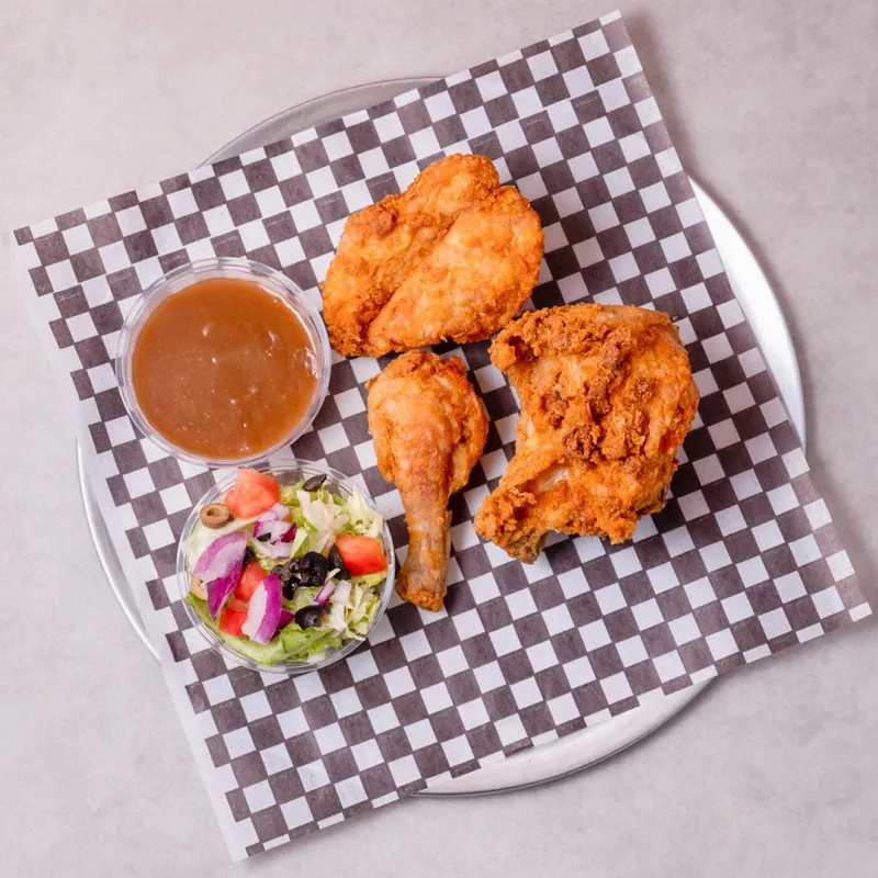 Crispy fried chicken wings with gravy and a side salad
